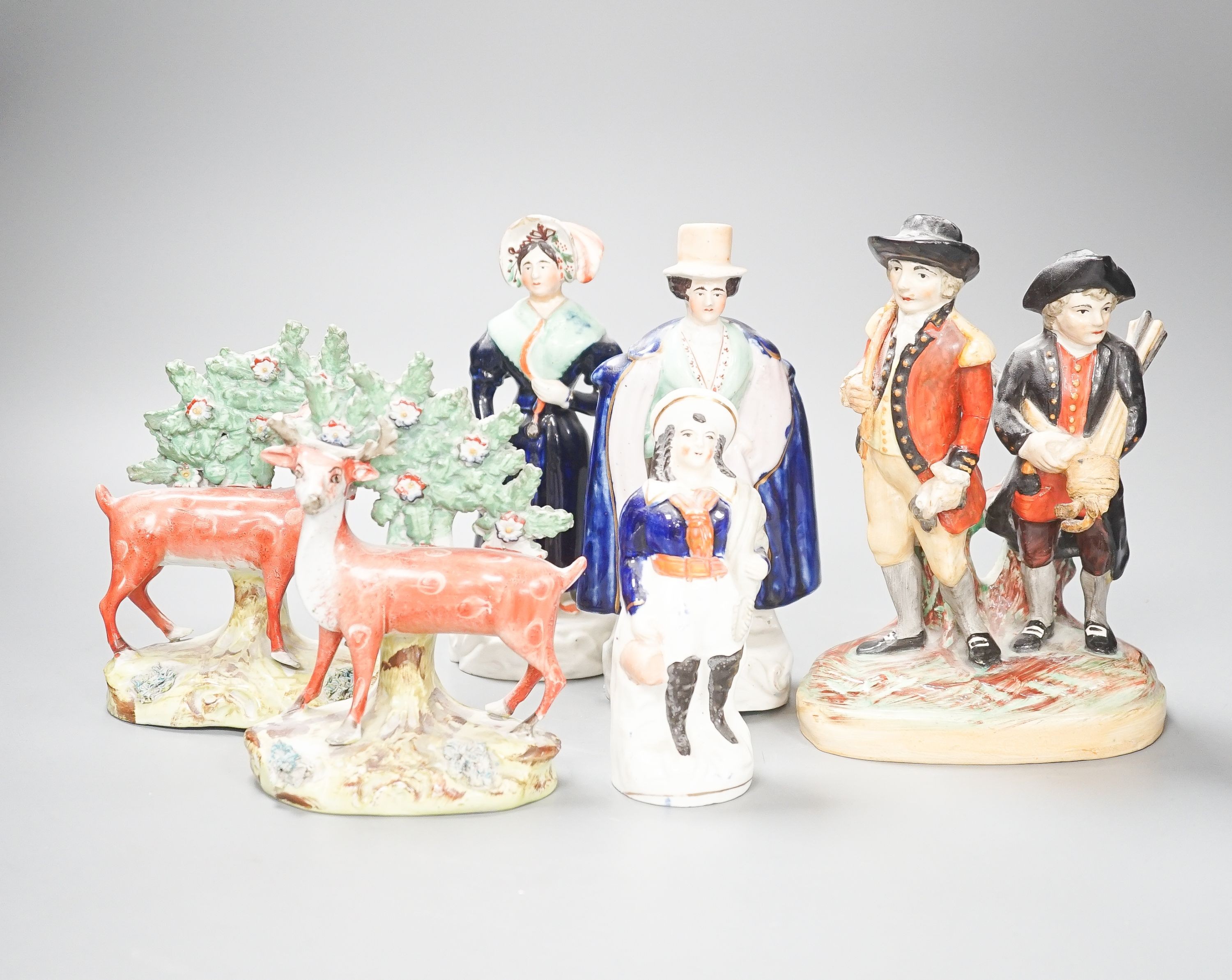 A group of Staffordshire figures, including a pair of deer standing before bocage, 15cm, a Victorian couple, 19 cm and a golfing group, 20 cm (6)